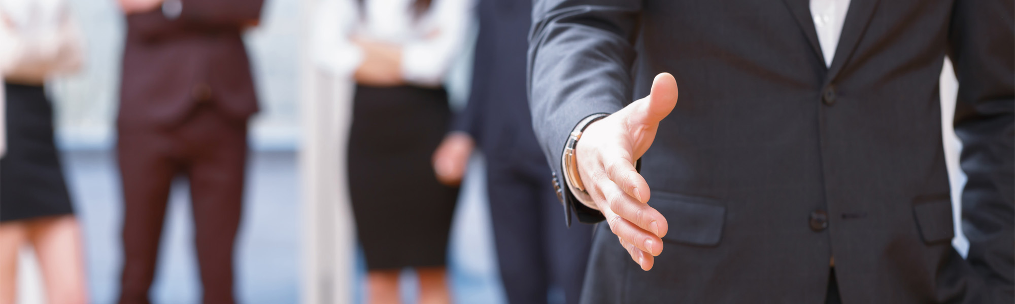 Young business man standing in front of his co-workers  talking